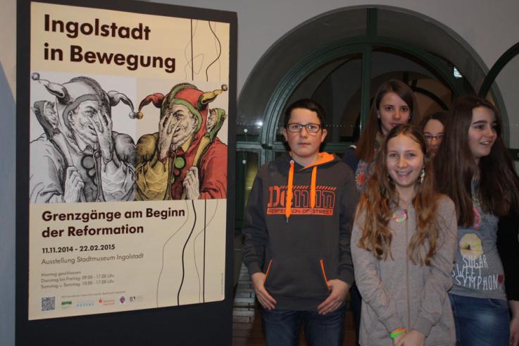 SchülerInnen vor dem Werbeplakat am Eingang zur Ausstellung